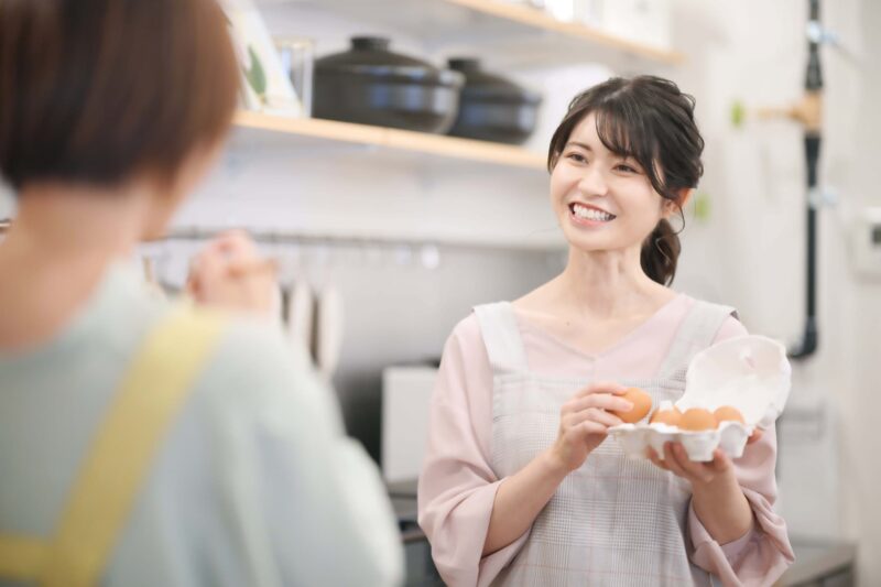 笑顔で料理する女性の画像