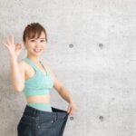 大きめのズボンを履いてダイエット成功を示す女性の画像